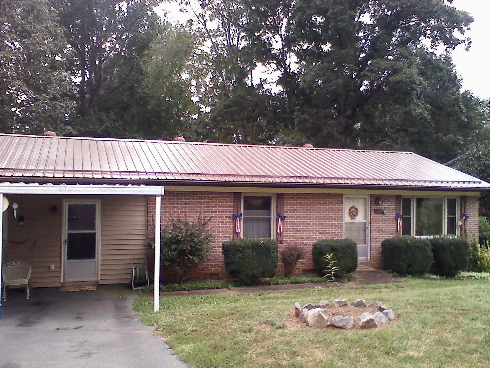 Bronze metal roof and carport on a brick ranch home — Roof Repair work by our crew in Mesquite